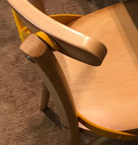 Particolare della sedia in legno massello di color pastello e color naturale